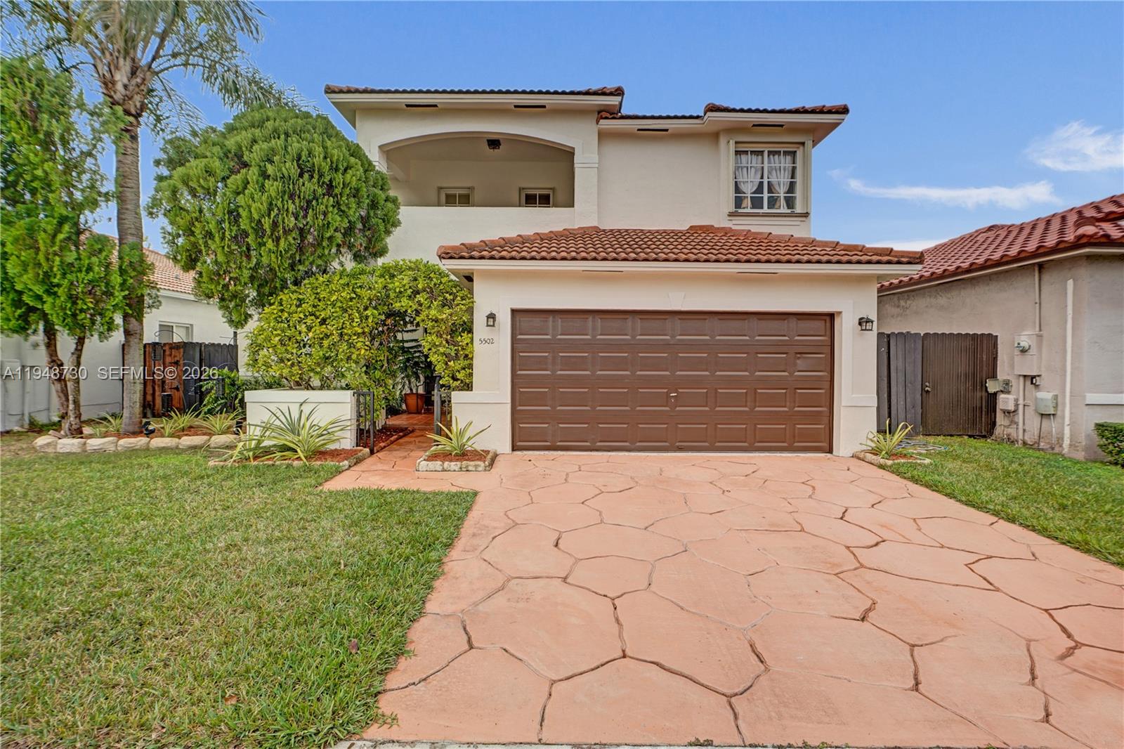 A two-story house features a brown garage door, a tiled roof, and a paved driveway — 5502 SW 162nd Pl, Miami FL 33185, MIAMI, FL