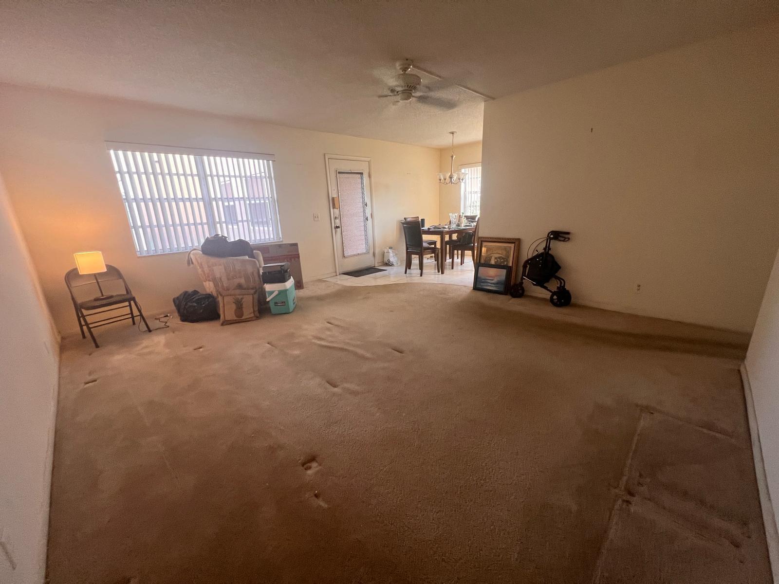 A living room with beige carpet, a ceiling fan, and an adjacent dining area — A Flanders # 5, Delray Beach FL 33484, DELRAY BEACH, FL