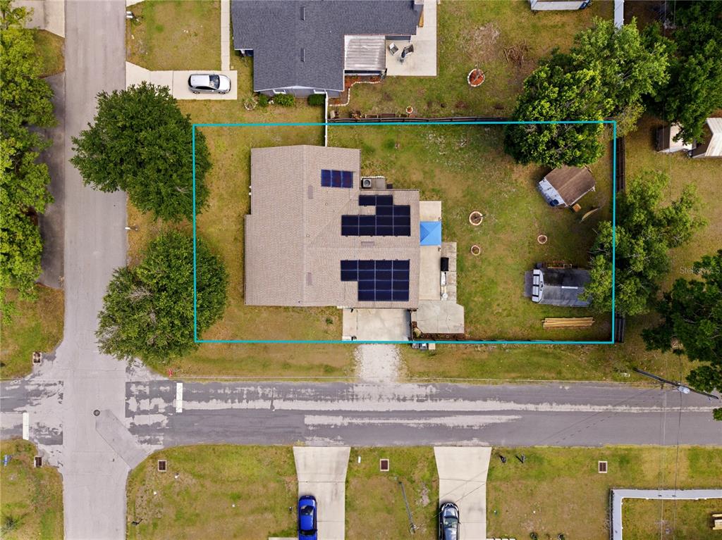 An aerial view shows a house with solar panels on its roof and a backyard — 1423 LOUISIANA AVENUE, ST CLOUD, FL