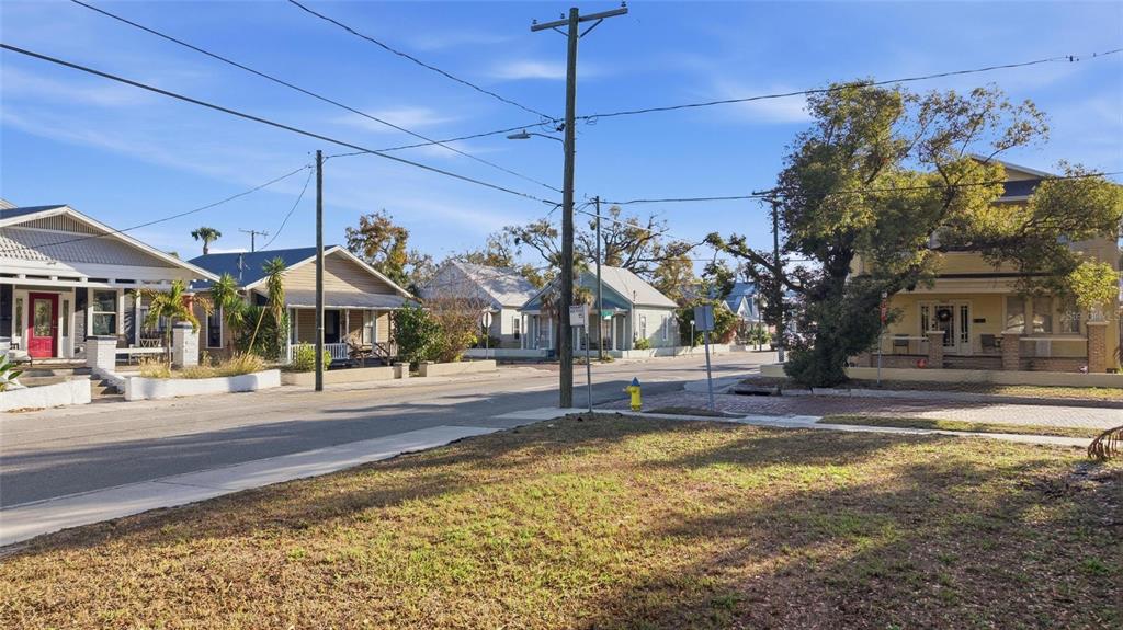 A street view showing a vacant grassy lot in the foreground and several houses nearby — 2616 N 19TH STREET, TAMPA, FL