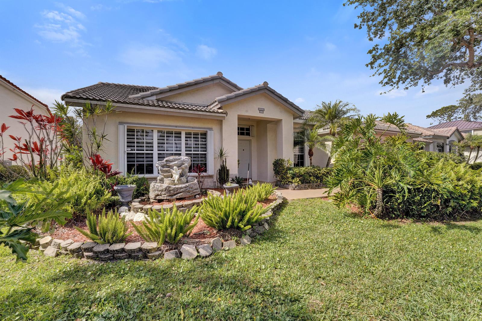 A single-story house with a stone fountain in the front garden and a tiled roof — 3460 Dunes Vista Drive, Pompano Beach FL 33069, POMPANO BEACH, FL