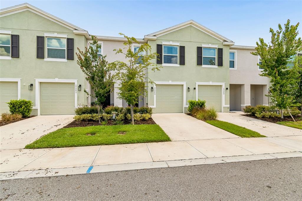 A hallway with light tile flooring, white walls, and a wooden decorative fireplace mantel console — 17245 AMBER ASPEN WAY, LAND O LAKES, FL