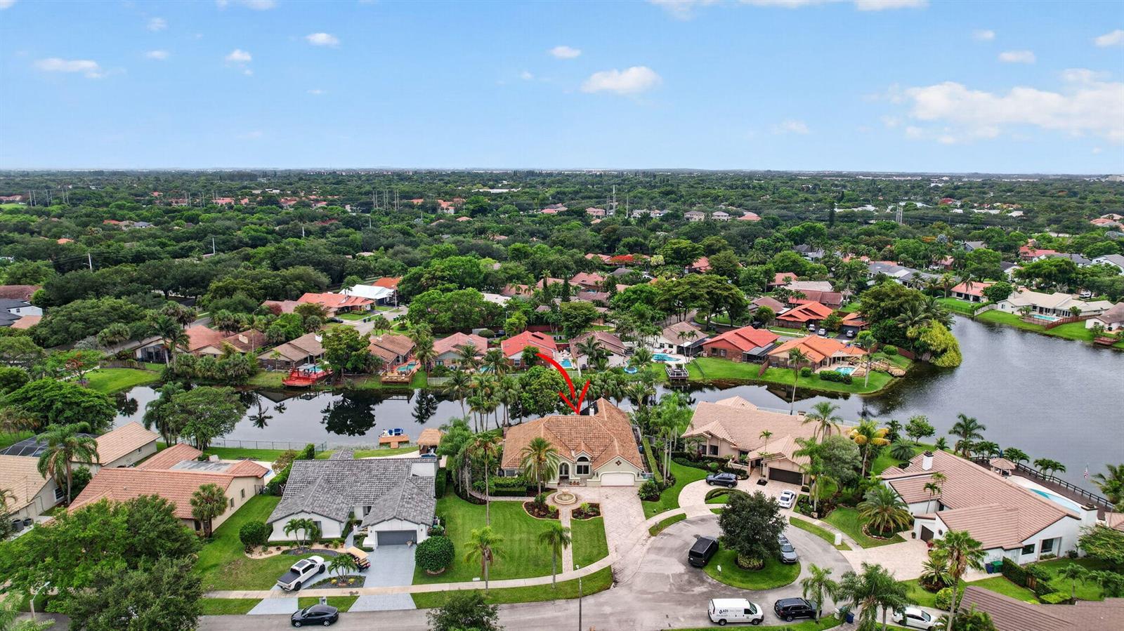 An aerial view shows a suburban house with a tile roof situated on a lakefront lot — 11380 Wayne Drive, Cooper City FL 33026, COOPER CITY, FL