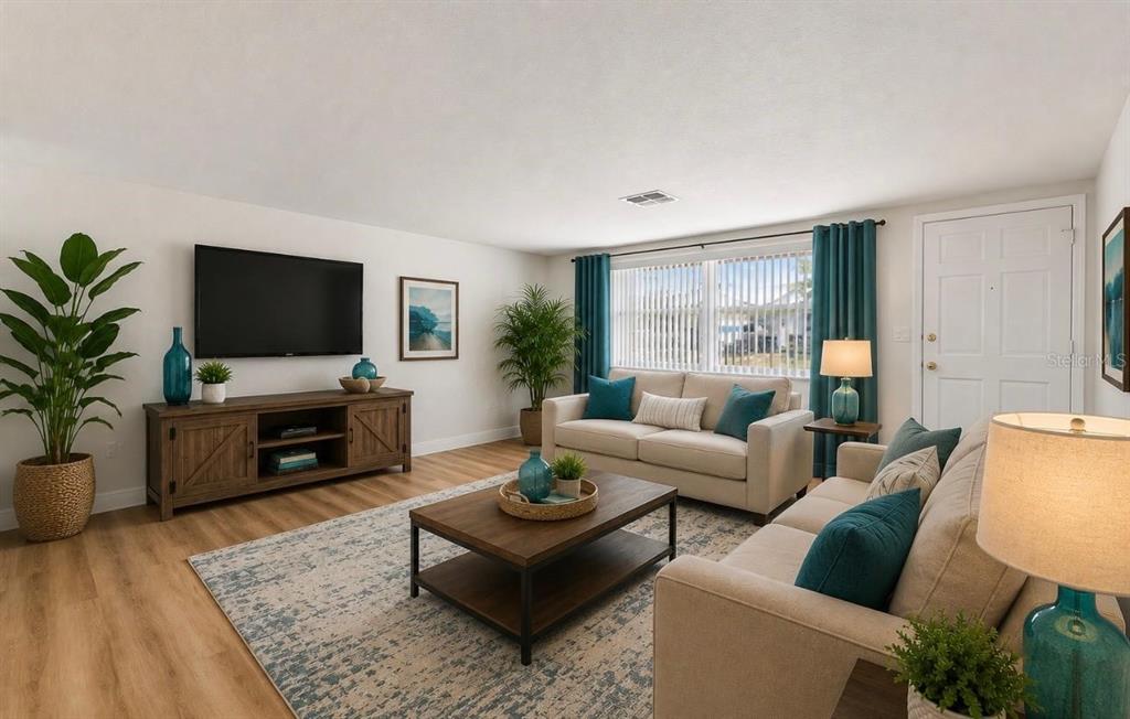 A living room features light wood flooring, a beige sofa, a coffee table, and a television — 7105 OAKSHIRE DRIVE, PORT RICHEY, FL