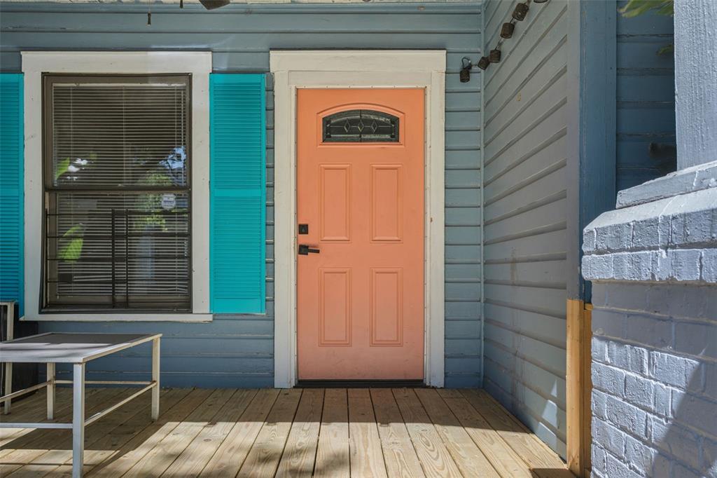 A peach-colored front door with a small window sits on a wooden porch — 4208 N MARGUERITE, TAMPA, FL