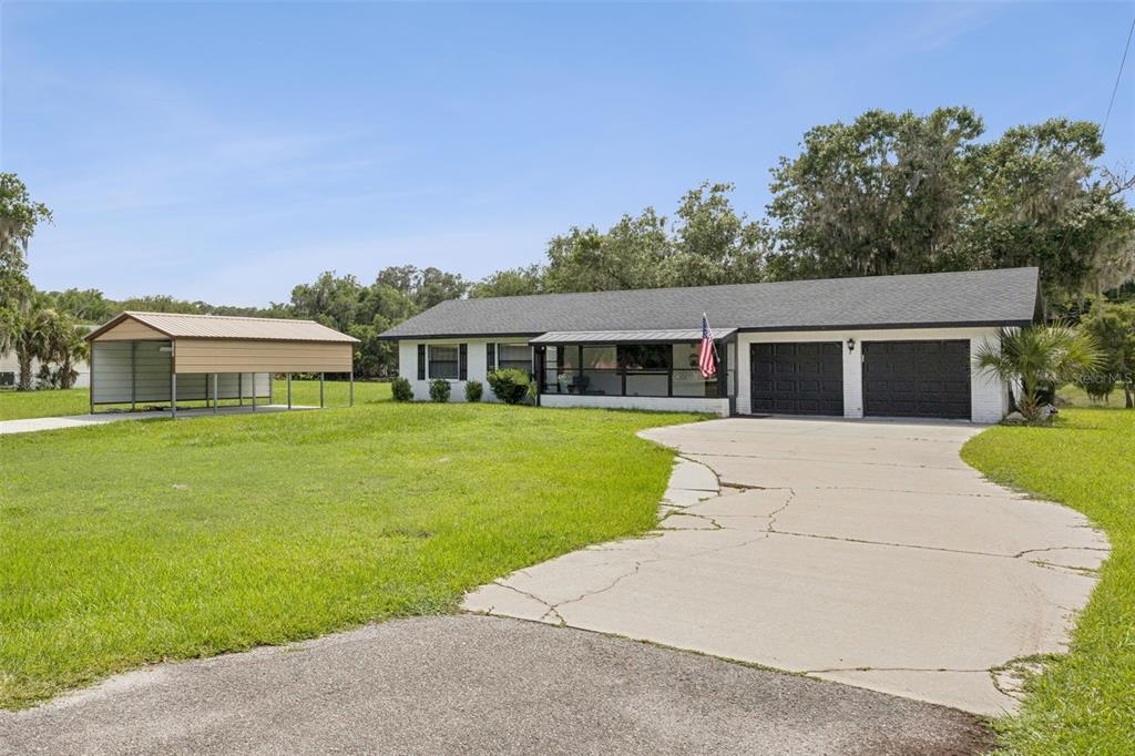A single-story house with a two-car garage, a front porch, and a detached metal carport — 2082 SHADY LANE, GENEVA, FL