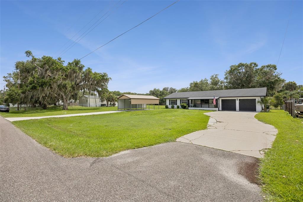 A single-story house with a two-car garage, a carport, and a large front lawn — 2082 SHADY LANE, GENEVA, FL