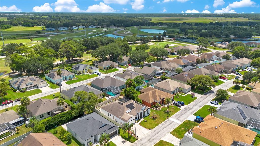 An aerial view shows a suburban neighborhood with houses, swimming pools, and a golf course — 216 BOXWOOD DRIVE, DAVENPORT, FL