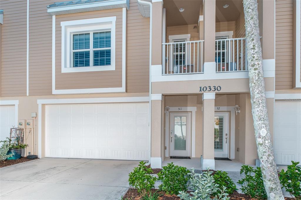 A two-story townhouse exterior features a garage, two front doors, and a second-floor balcony — 10330 LONGSHORE ROAD UNIT 51, PLACIDA, FL