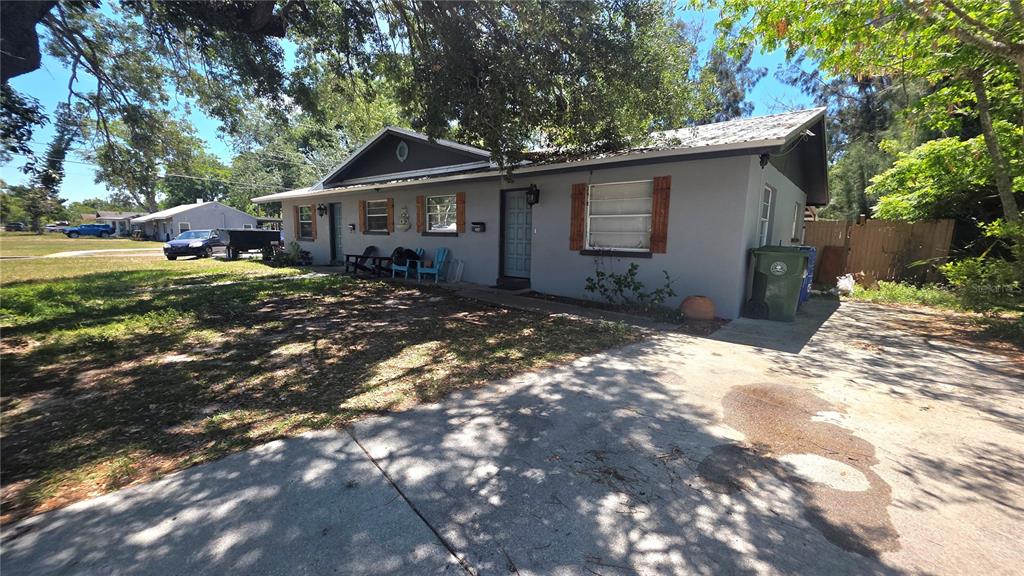 A single-story gray house with a concrete driveway and a front yard with trees — 2126 2ND AVENUE E, BRADENTON, FL