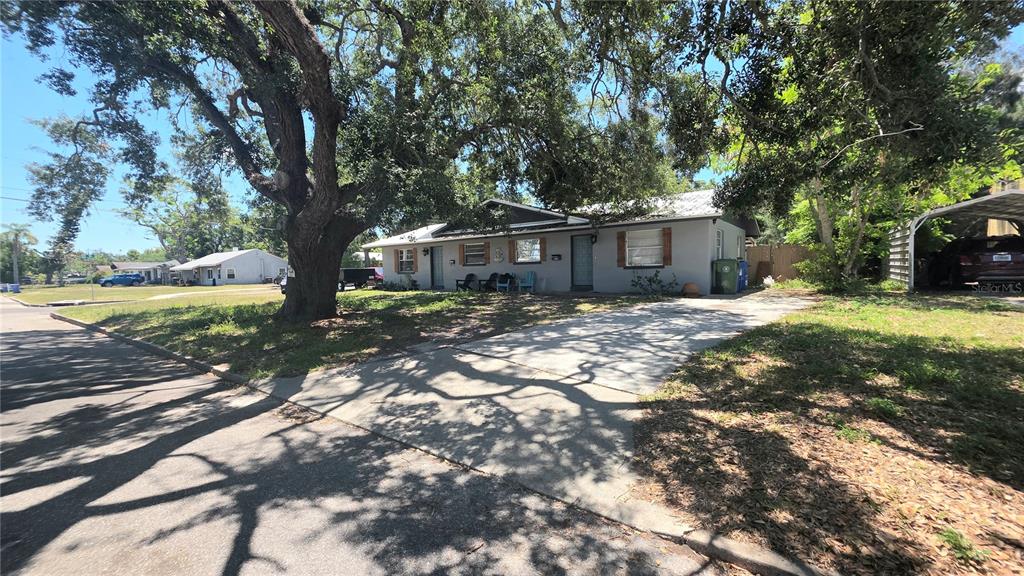 A single-story house with a concrete driveway and large shade trees in the front yard — 2126 2ND AVENUE E, BRADENTON, FL