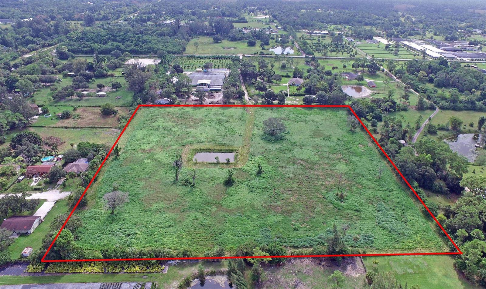 An aerial view shows a large, rectangular grassy lot outlined in red with a small pond — 3793 D Road, FL 33470, FL