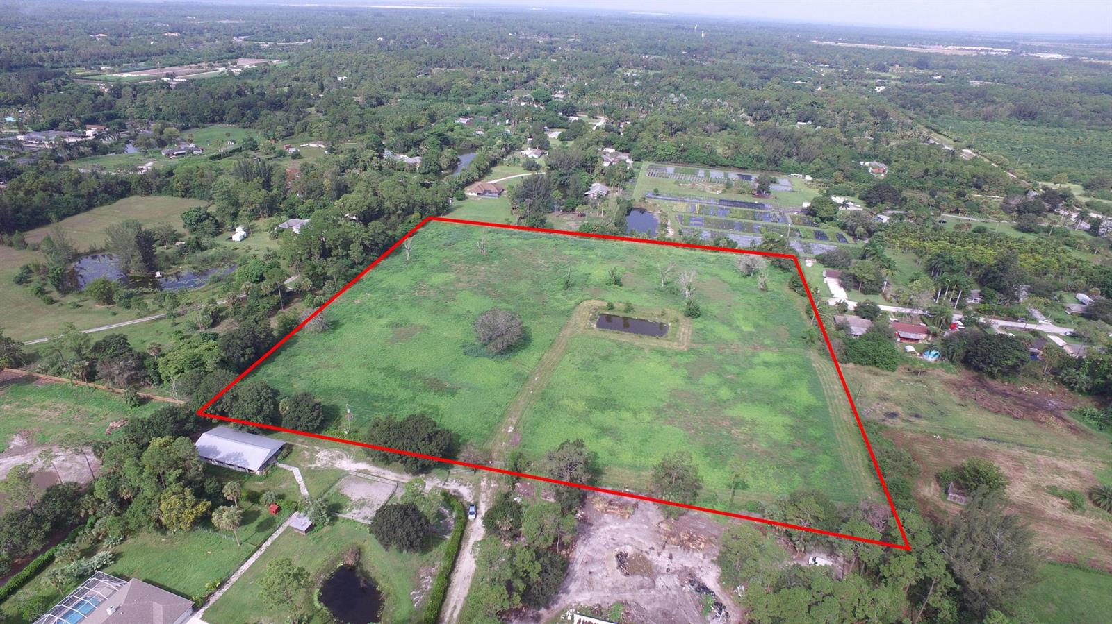 An aerial view shows a large, rectangular grassy lot outlined in red — 3793 D Road, FL 33470, FL