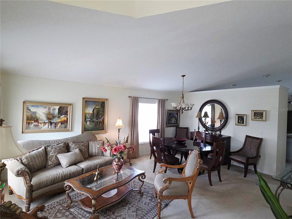 A living and dining room area features a sofa, coffee table, and wooden dining set — 3849 ROLLINGSFORD CIRCLE, LAKELAND, FL