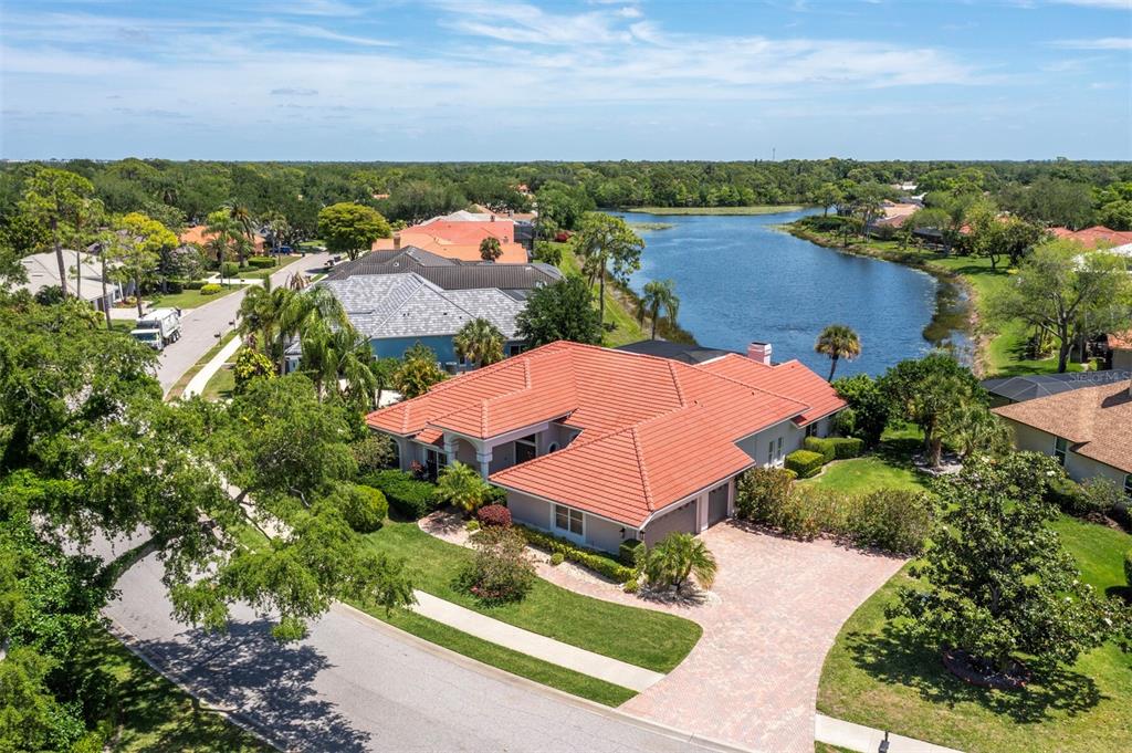 An aerial view of a single-story house with a red tile roof near a lake — 8615 WOODBRIAR DRIVE, SARASOTA, FL