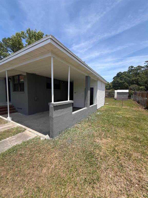 A covered concrete patio with gray stucco walls and white support columns attached to a house — 3761 JAMMES ROAD, JACKSONVILLE, FL