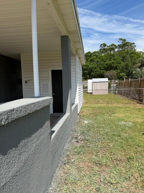 A view of a covered patio with a gray stucco wall and a black door — 3761 JAMMES ROAD, JACKSONVILLE, FL