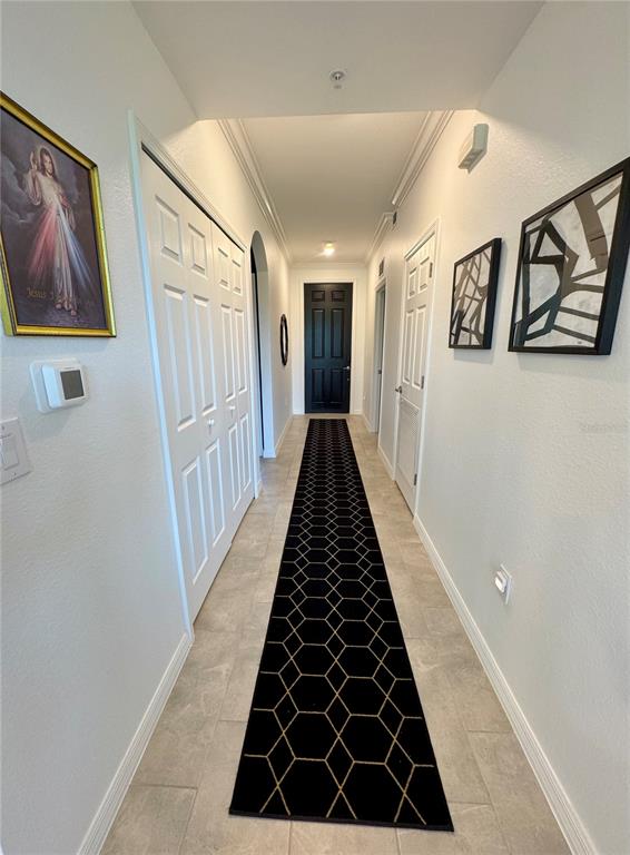 A hallway features light tile flooring, a geometric black runner, and white doors — 18028 GAWTHROP DRIVE UNIT 303, BRADENTON, FL