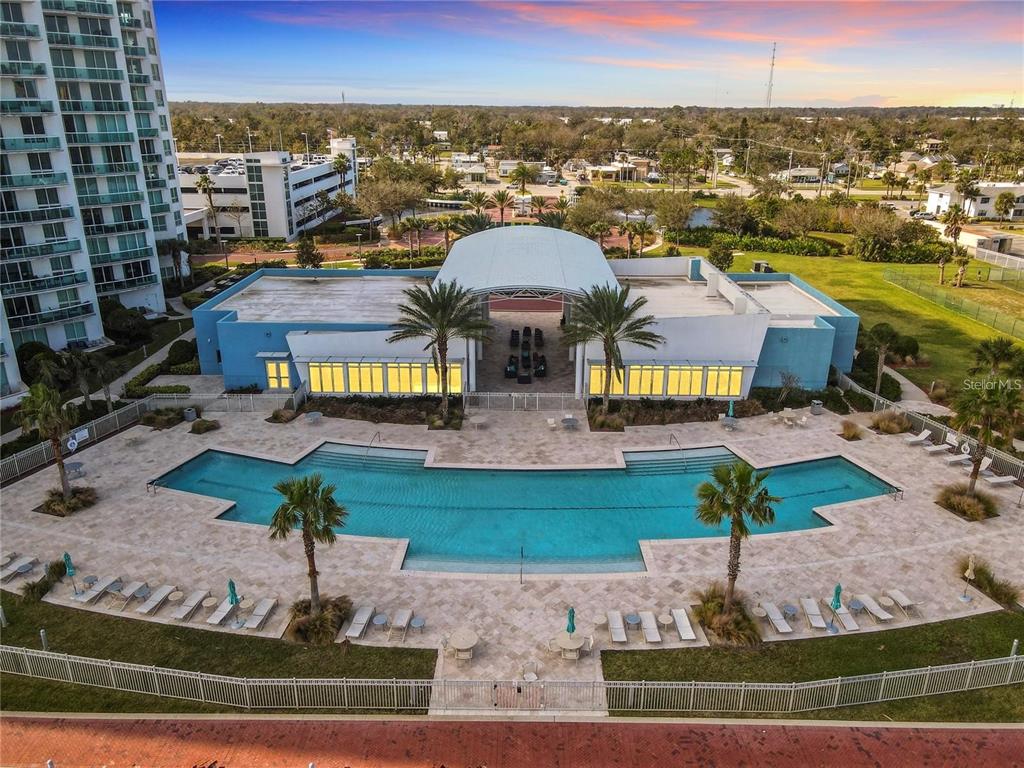 An aerial view shows a swimming pool and patio area in front of a clubhouse building — 241 RIVERSIDE DRIVE UNIT 1809, DAYTONA BEACH, FL