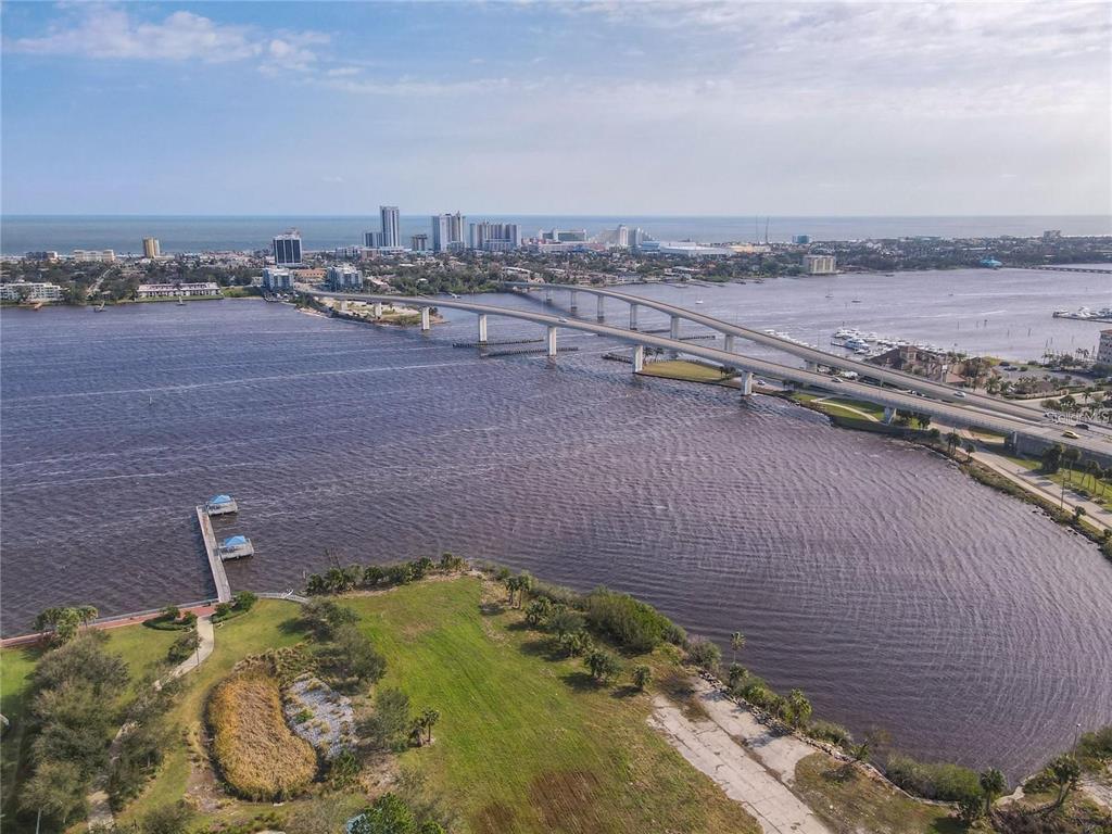 An aerial view shows a bridge spanning a river with a city skyline in the distance — 241 RIVERSIDE DRIVE UNIT 1809, DAYTONA BEACH, FL