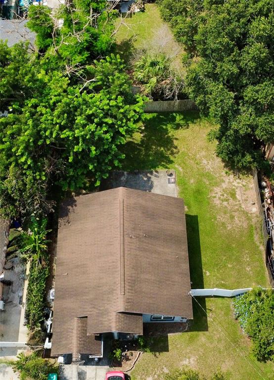 An aerial view shows a house with a brown roof surrounded by trees and grass — 310 PRINCE STREET, ORLANDO, FL