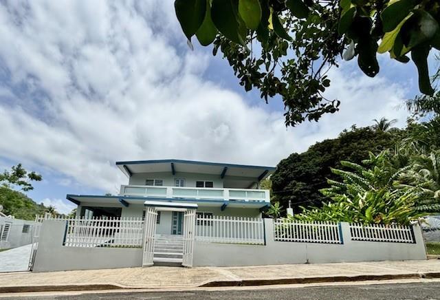 A two-story house with a white fence stands under a cloudy sky — Bo Quebrada Fajardo CARR#985 KM 1.3 Lote#5, FAJARDO, PR