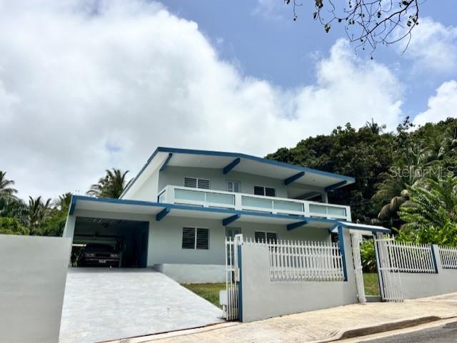 A two-story house with a carport and a white fence under a cloudy sky — Bo Quebrada Fajardo CARR#985 KM 1.3 Lote#5, FAJARDO, PR