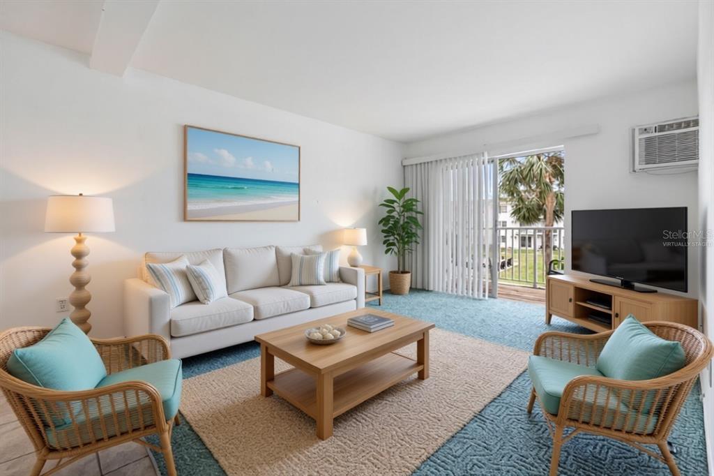 A living room features a sofa, two wicker chairs, a coffee table, and a balcony view — 2326 CANAL DRIVE UNIT G25, BRADENTON, FL