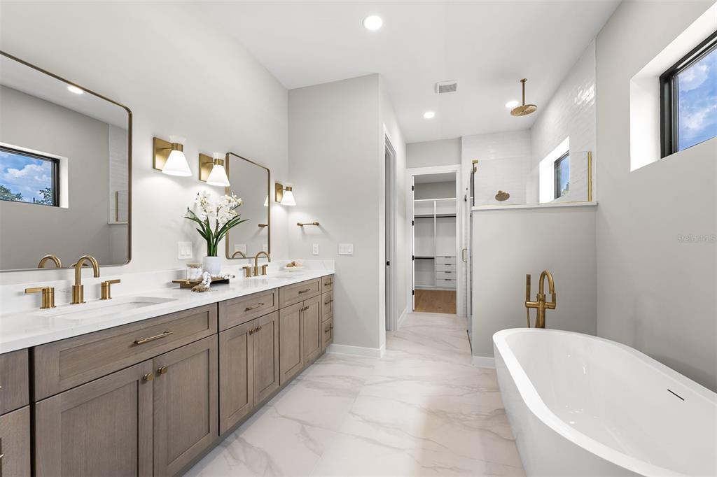 A modern bathroom features a double vanity, a freestanding tub, and a walk-in closet — 106 W KING STREET, ORLANDO, FL