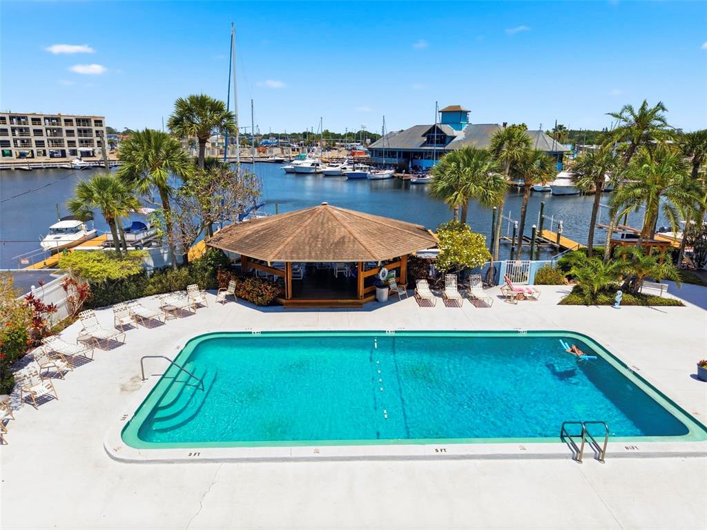 An outdoor swimming pool sits on a concrete deck next to a gazebo and marina — 4939 FLORAMAR TERRACE UNIT 501, NEW PORT RICHEY, FL