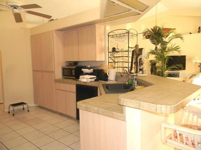 A kitchen with light wood cabinets, tiled countertops, and a breakfast bar — 212 BOA VISTA STREET, PUNTA GORDA, FL