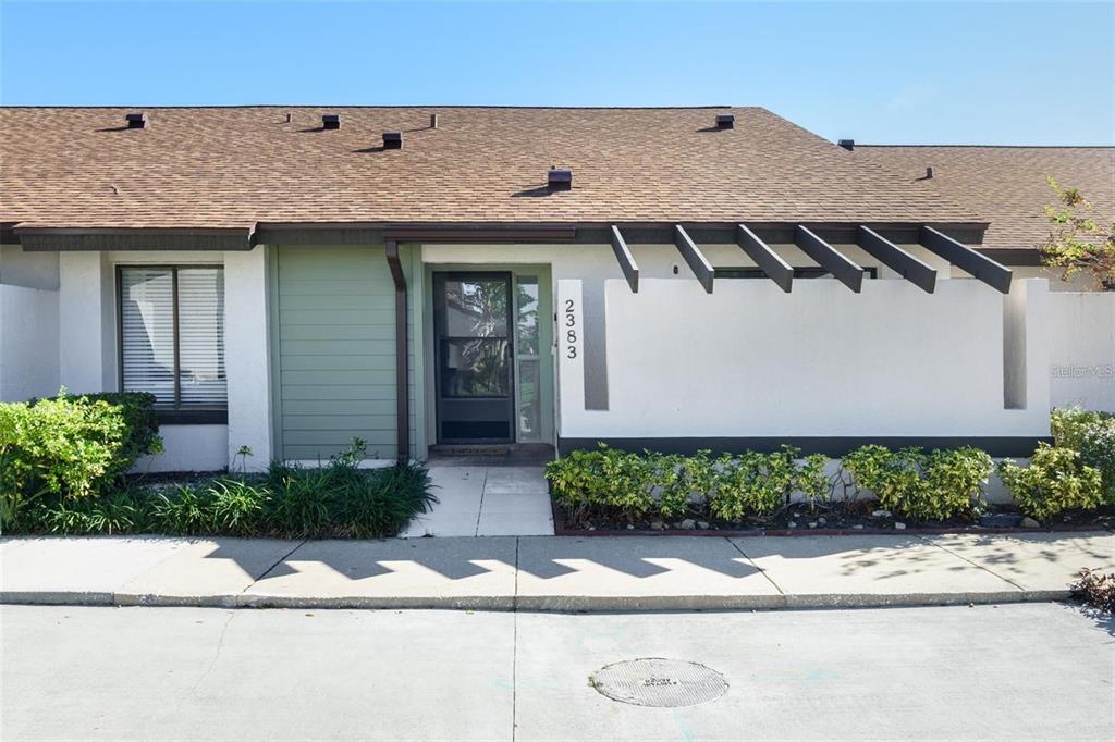 The exterior of a single-story residential unit features a front entrance and a pergola — 2383 SUN VALLEY CIRCLE UNIT 2383, WINTER PARK, FL