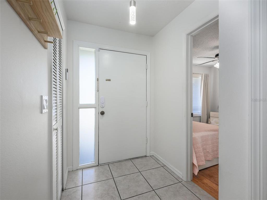 A tiled entryway features a white front door with sidelights and an adjacent bedroom doorway — 2383 SUN VALLEY CIRCLE UNIT 2383, WINTER PARK, FL