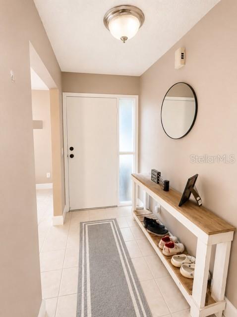 An entryway features a white door, a console table with shoes, and a round mirror — 2746 MENDELIN STREET, APOPKA, FL