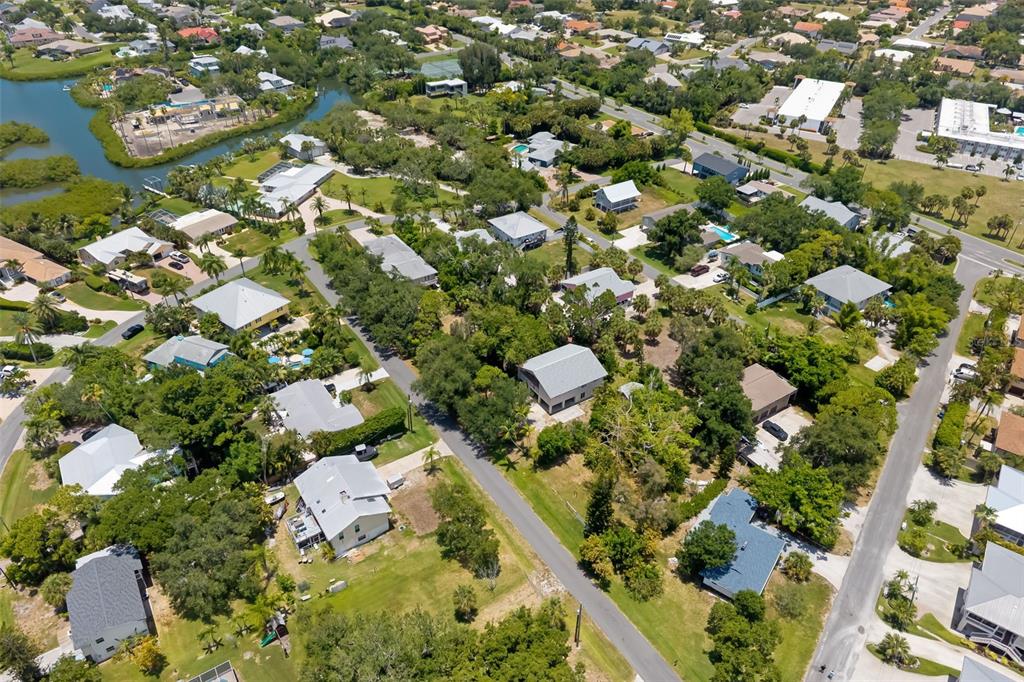 An aerial view shows a residential neighborhood with houses, lush trees, and a nearby waterway — 0 WESTVIEW DRIVE, OSPREY, FL