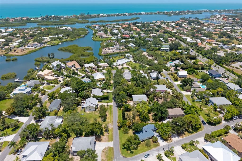 Aerial view of a coastal residential neighborhood with houses, lush trees, and nearby waterways — 0 WESTVIEW DRIVE, OSPREY, FL