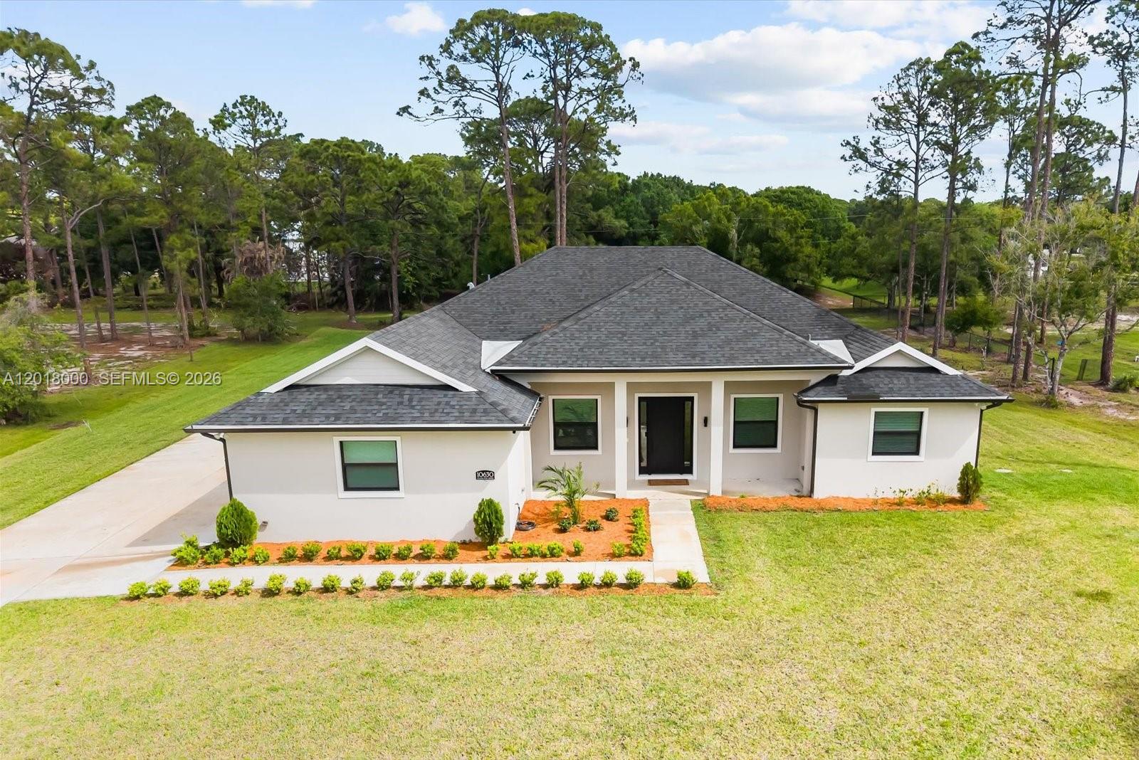 A single-story house with a white exterior, dark roof, and a front walkway — 10630 Sugar Pine Dr, Fort Pierce FL 34945, FORT PIERCE, FL