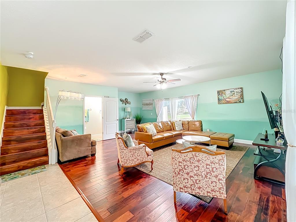 A living room features hardwood floors, a brown sectional sofa, and light green walls — 10100 GREEN BRANCH COURT, ORLANDO, FL