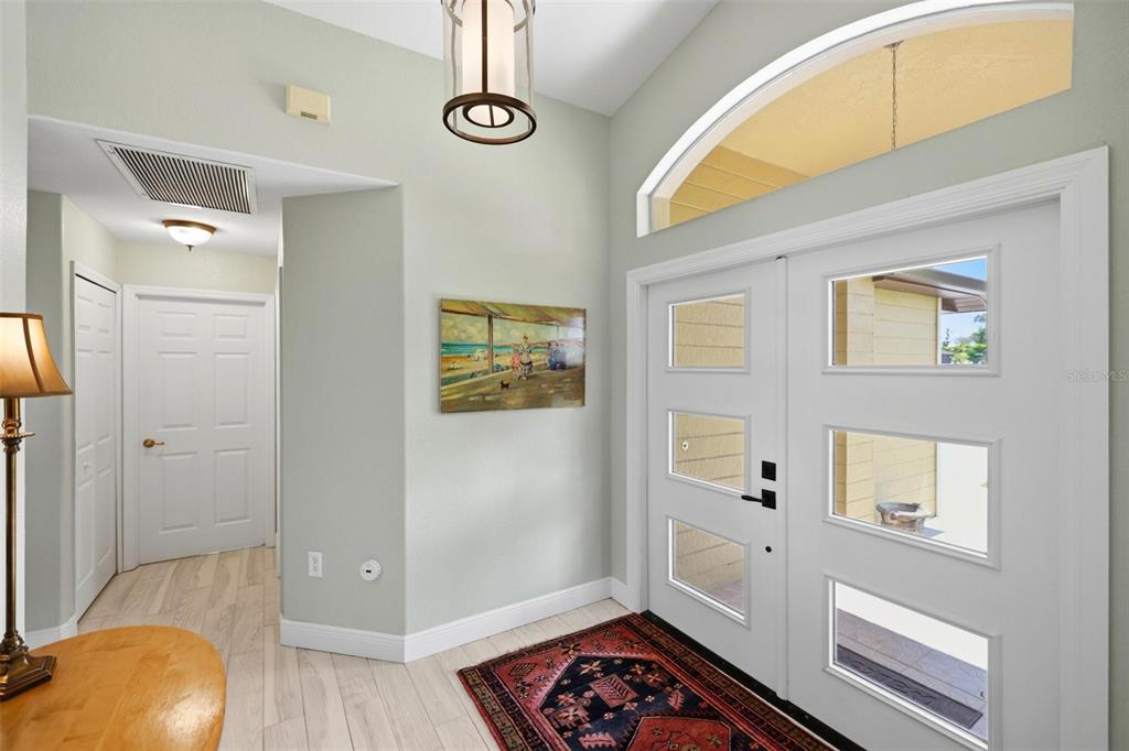 An entryway features a white double door, a patterned rug, and a light-colored wood floor — 894 BOUNDARY BOULEVARD, ROTONDA WEST, FL