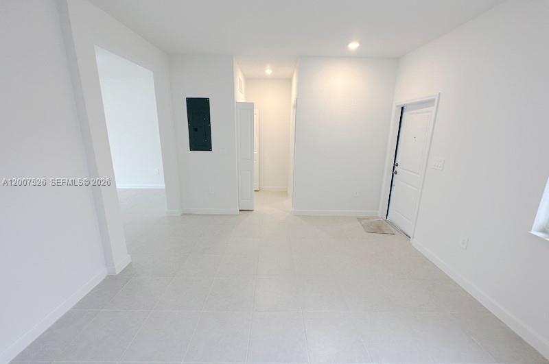 An interior view of a room with white walls, tile flooring, and a doorway — 12428 NW 23rd Ct, Miami FL 33167, MIAMI, FL