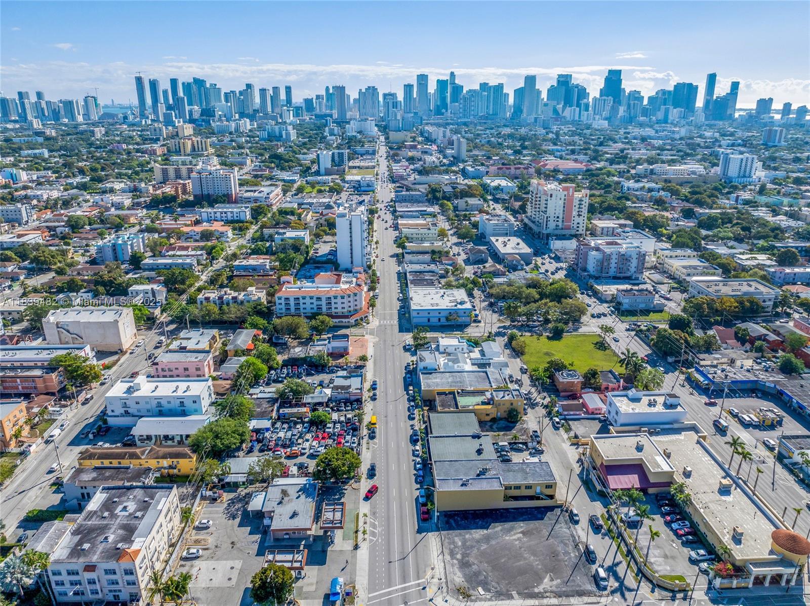An aerial view shows a city street extending toward a distant skyline of high-rise buildings — 1554 W Flagler St, Miami FL 33135, MIAMI, FL