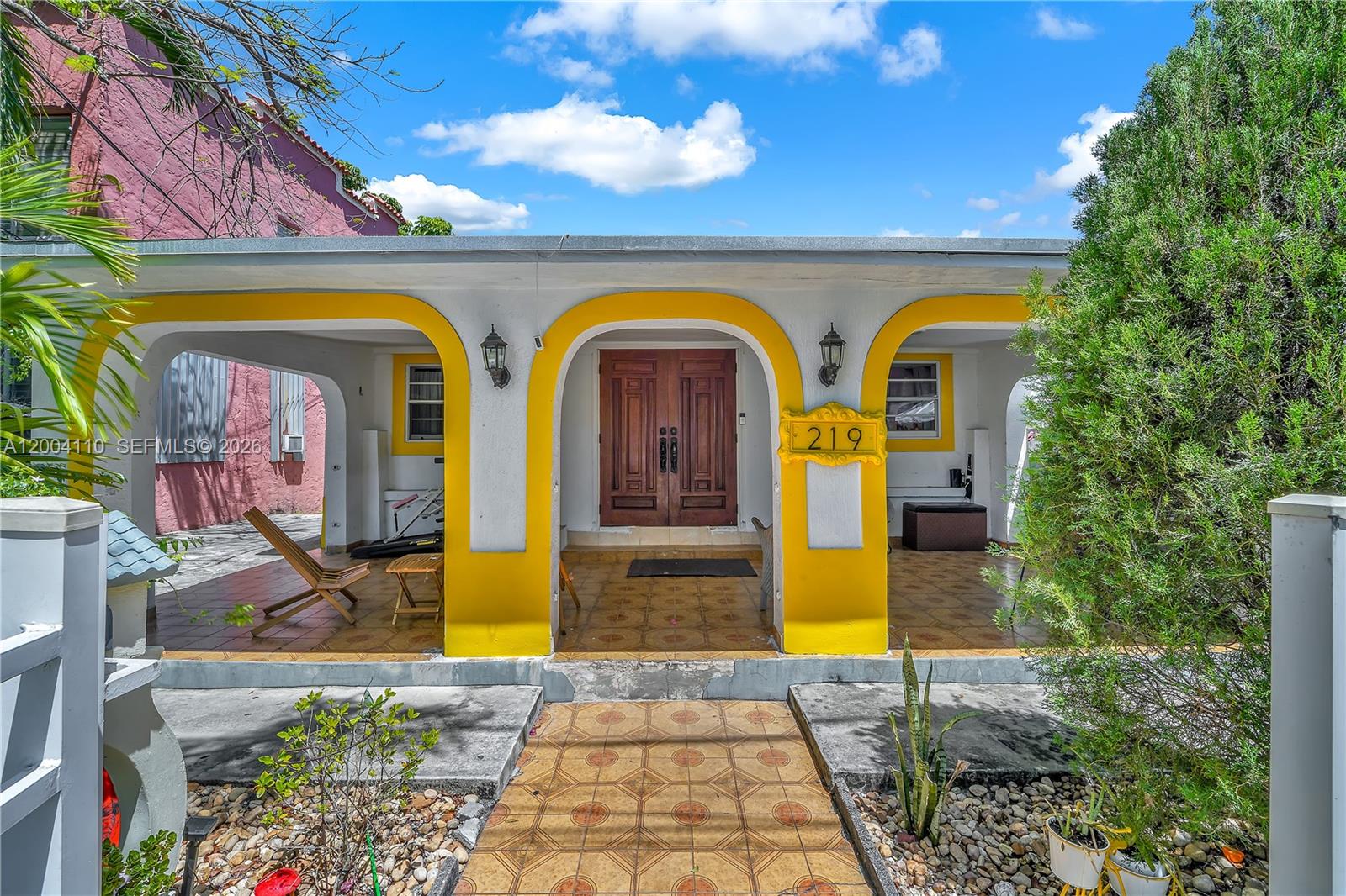 A house exterior features a covered porch with yellow arched columns and double wooden doors — 219 SW 6th Ave, Miami FL 33130, MIAMI, FL