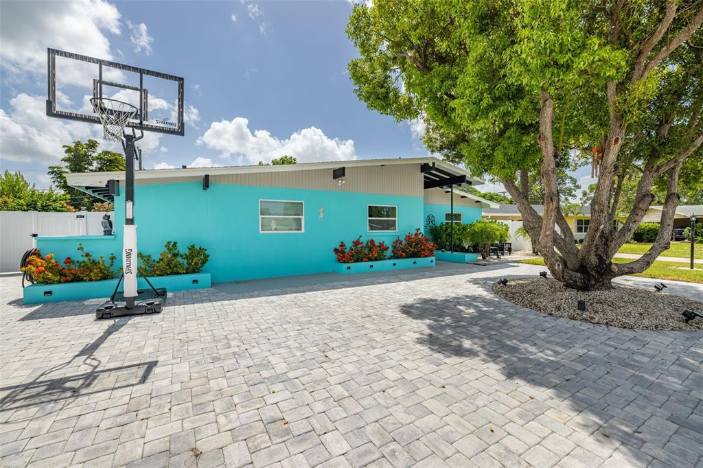 A turquoise house with a paved driveway, a basketball hoop, and a large tree — 3407 29TH STREET W, BRADENTON, FL