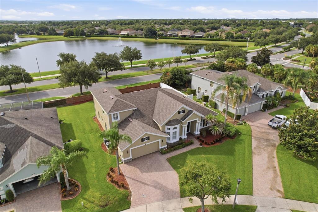 An aerial view shows a suburban house with a tan exterior, shingled roof, and paved driveway — 426 DUFF DRIVE, WINTER GARDEN, FL