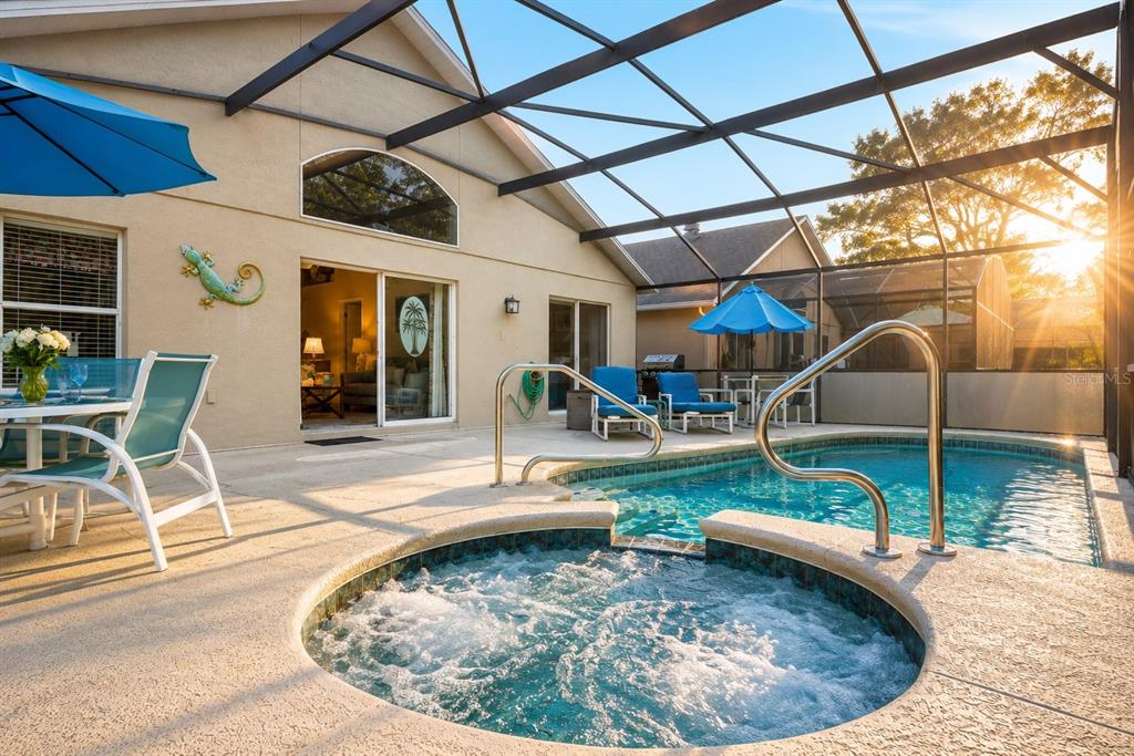 A screened-in patio features a swimming pool, a hot tub, and outdoor seating — 138 MADIERA BEACH BOULEVARD, KISSIMMEE, FL