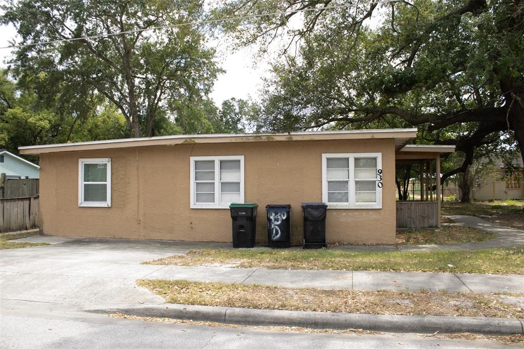 A single-story tan house with a concrete driveway and three trash cans in front — 621 W SOUTH STREET, ORLANDO, FL