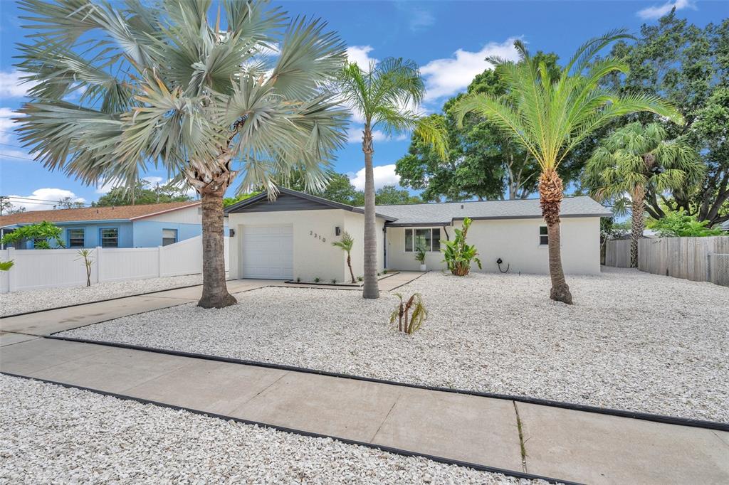 A single-story house with a white exterior, a garage, and palm trees in the yard — 2310 MARY SUE STREET, LARGO, FL