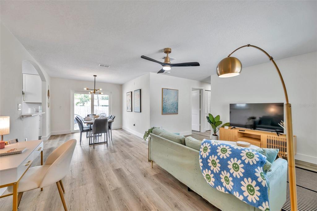 A living room and dining area feature wood-look flooring, a sofa, and a television — 2310 MARY SUE STREET, LARGO, FL