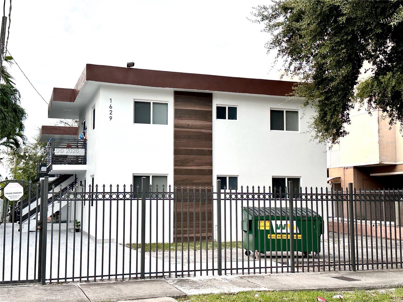 A two-story white apartment building features a brown accent panel and a metal perimeter fence — 1629 SW 3rd St # 5, Miami FL 33135, MIAMI, FL