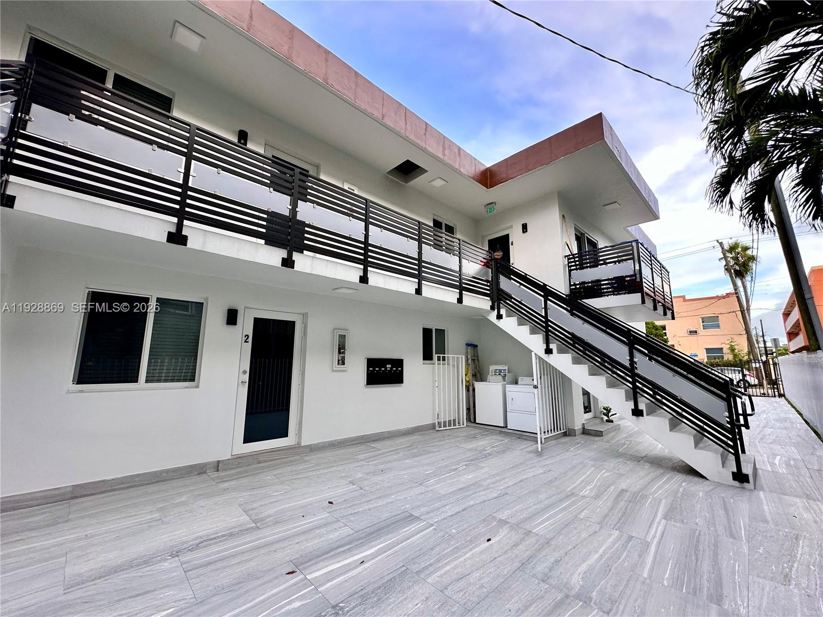 An exterior view of a two-story apartment building with a staircase and metal railings — 1629 SW 3rd St # 5, Miami FL 33135, MIAMI, FL